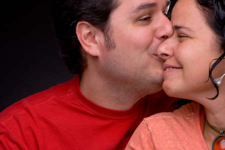 beautiful couple kissing in the studio, black background,の写真素材