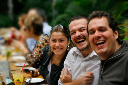 tables with a group of smiling friends, narrow focus,