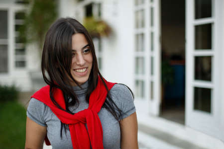 Beautiful brunette woman with long hair smiling with a red blouse tied around her neck,の写真素材