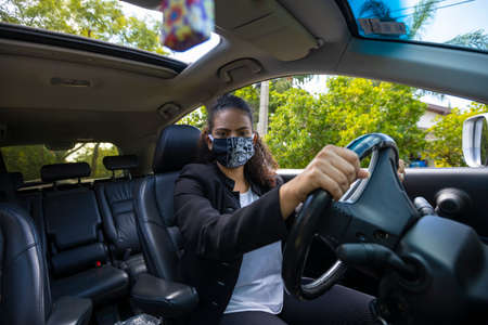 Woman driving with a mask during the coronavirus pandemicの写真素材