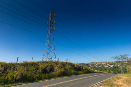 power transmission towers next to the road with blue sky in the background,の写真素材