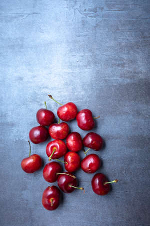 Ripe sweet cherry spread on a blue background. seen from above. Free space for edits.