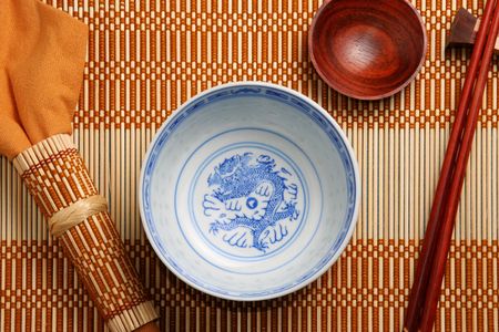 Top view of asian tableware (bowl, sauce cup, chopsticks and napkin) on a bamboo tablematの写真素材