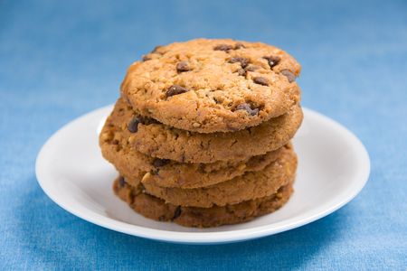 A stack of hazelnut and chocolate chips cookies on a white plate