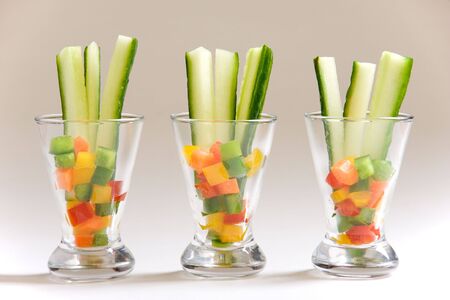 Three appetizer glasses filled with sliced vegetablesの写真素材