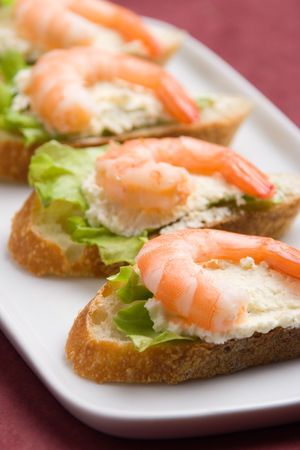 Closeup view of shrimp toasts with salad and garlic cheese (shallow DOF)の写真素材