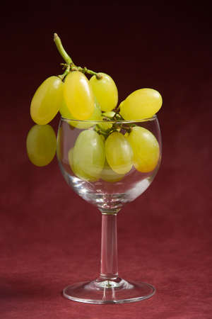 White grapes in a glass over a purple backgroundの写真素材