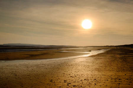 Sunset over Camber Sands Beach at low tide, East Sussex Englandの写真素材