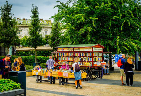 Budapest, Hungary, Aug 2019, people on a town square by a book cart