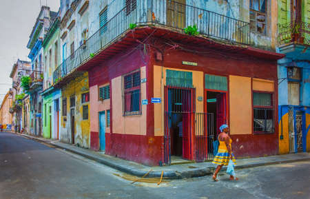 Havana, Cuba, July 2019, woman walking by a food store at the corner of Calle Muralla & Cuba in the oldest part of the cityのeditorial素材