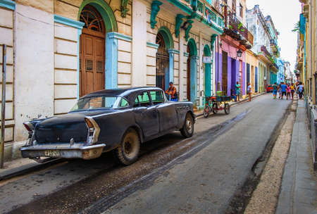 Havana, Cuba, July 2019, urban scene in the oldest part of the city with a black American 1950's car parked in Calle Cubaのeditorial素材