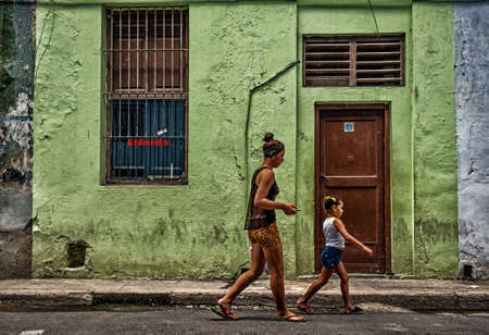 Havana, Cuba, July 2019, girls walking in front of a colorful house wall in the old part of the cityのeditorial素材