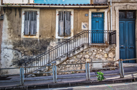 Marseille, France, Oct 2020, close up of a old house facade with a external stairs on a steep street of the cityの写真素材