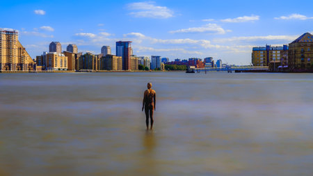 England, UK, Sept 2018, statue by Antony Gormley in the river Thames at high tide in the East of London by the Thames Pathのeditorial素材