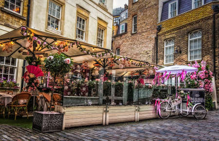 London, U.K, March 2019, view of a pink tricycle bike parked by the courtyard bar of Mews of Mayfair...