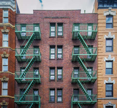New York City, USA, May 2019, view of a red brick building with fire escape in the West Village...