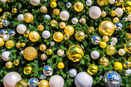 Close up of a heavy decorated Christmas tree with golden, silver, and white baublesの写真素材
