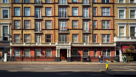England, United Kingdom, Aug 30th 2023, view of a couple walking past Mary George House, a residential building in the Royal Borough of Kensington and Chelseaの写真素材