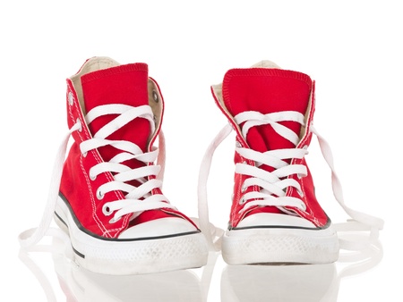 Red vintage canvas sneakers untied on white backgroundの写真素材