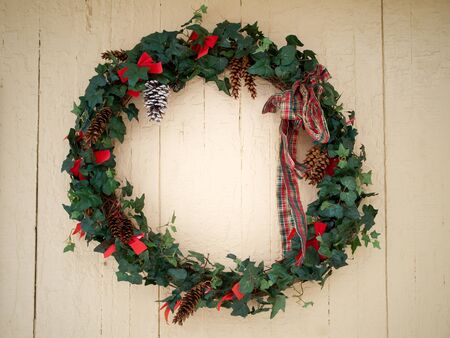 Christmas ivy wreath on painted old wall in winterの写真素材