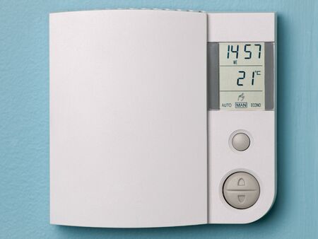 Electronic programmable thermostat on blue wallの写真素材