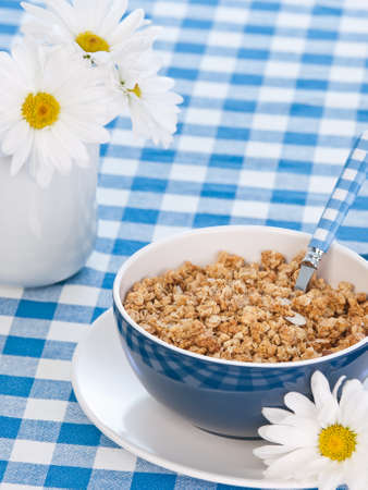 Breakfast cereal  on the  table with milk and flowersの写真素材