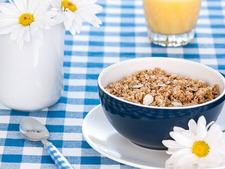 Breakfast cereal  on the  table with milk and flowersの写真素材