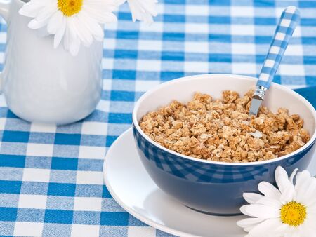 Breakfast cereal  on the  table with milk and flowersの写真素材