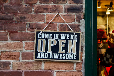 âCome in weâre open and awesome.â A playful sign invites customers into a store.の写真素材
