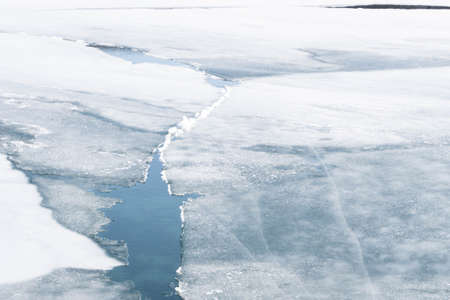 An ice floe breaks ups in the spring thaw revealing the frigid water below.の写真素材