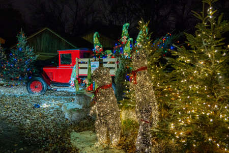 An outdoor Christmas night scene includes glowing trees, a classic red truck and an old barn.の写真素材
