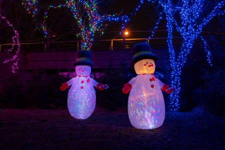 Two illuminated Christmas snowmen bring festive cheer in the nights before Christmas.の写真素材