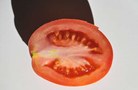 Tomato cut in half on a white background, close-upの写真素材
