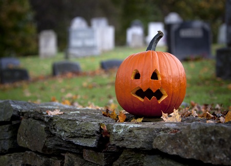 Spooky pumpkin with graveyard background in Fall