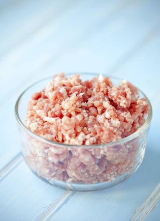 Freshly ground pork in a bowl on a table.の写真素材