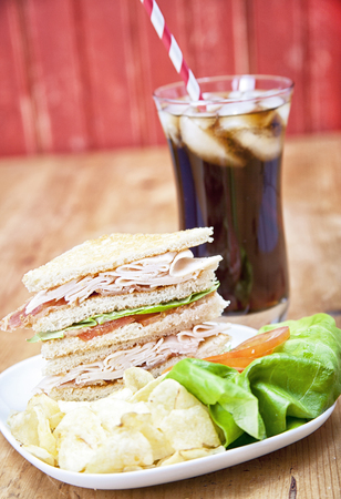 Turkey Club Sandwich with chips and sodaの写真素材