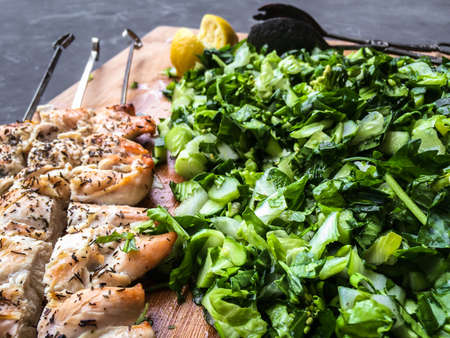 seasoned chicken on scewers with romaine, Italian parsley and other green vegetablesの写真素材