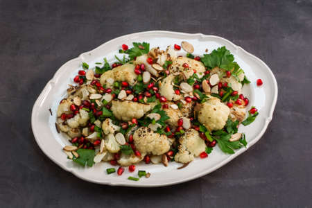 Pomegranate Cauliflower salad with italin parsley and sliced almondsの写真素材
