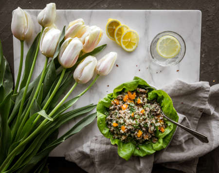 Qinoa mushroom bell pepper salad with water and tulipsの写真素材