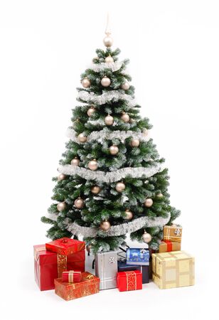 Artificial christmas tree isolated on white, decorated with golden ornaments and silver garland, a lot of presents under the treeの写真素材