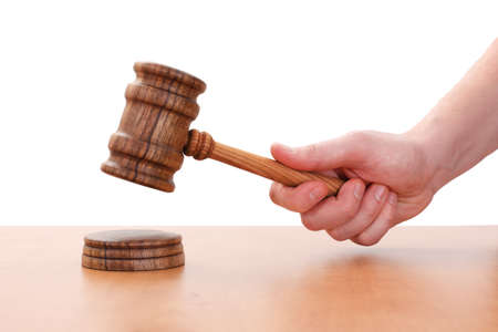 Hand hitting down with wooden gavel; Auction conceptの写真素材
