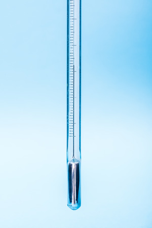 Industrial mercury thermometer on blue backgroundの写真素材