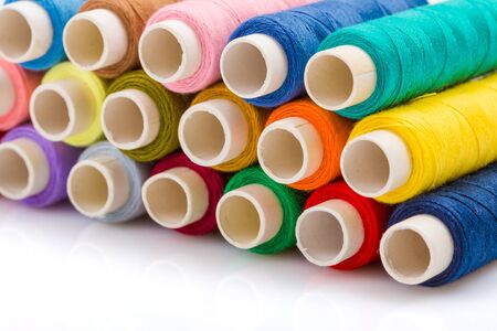 Macro of colorful sewing threads on white surface