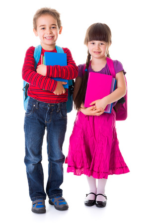 Cute little schoolgirl and schoolboy standing and holding booksの写真素材