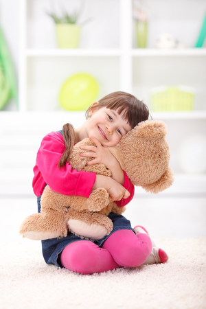 Little girl playing, loving her plush bearの写真素材