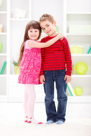 Happy little sister hugging her brotherの写真素材