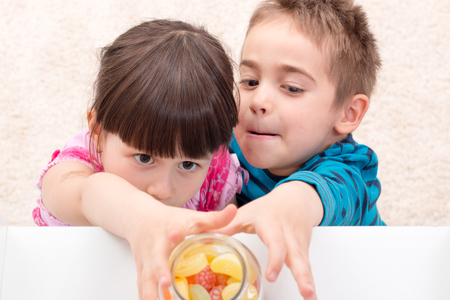 Children trying to take candy put asideの写真素材