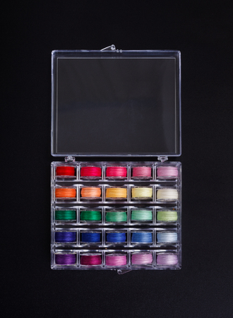 Plastic sewing machine with colorful threads bobbins in storage boxの写真素材