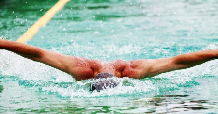 Swimmer performing the butterfly stroke の写真素材