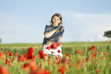 Young casual woman relaxing in poppy fieldの写真素材
